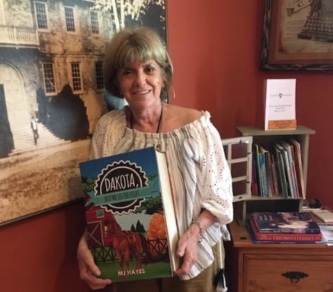 Author MJ Hayes with her book “Dakota, Help Me See the Light.”